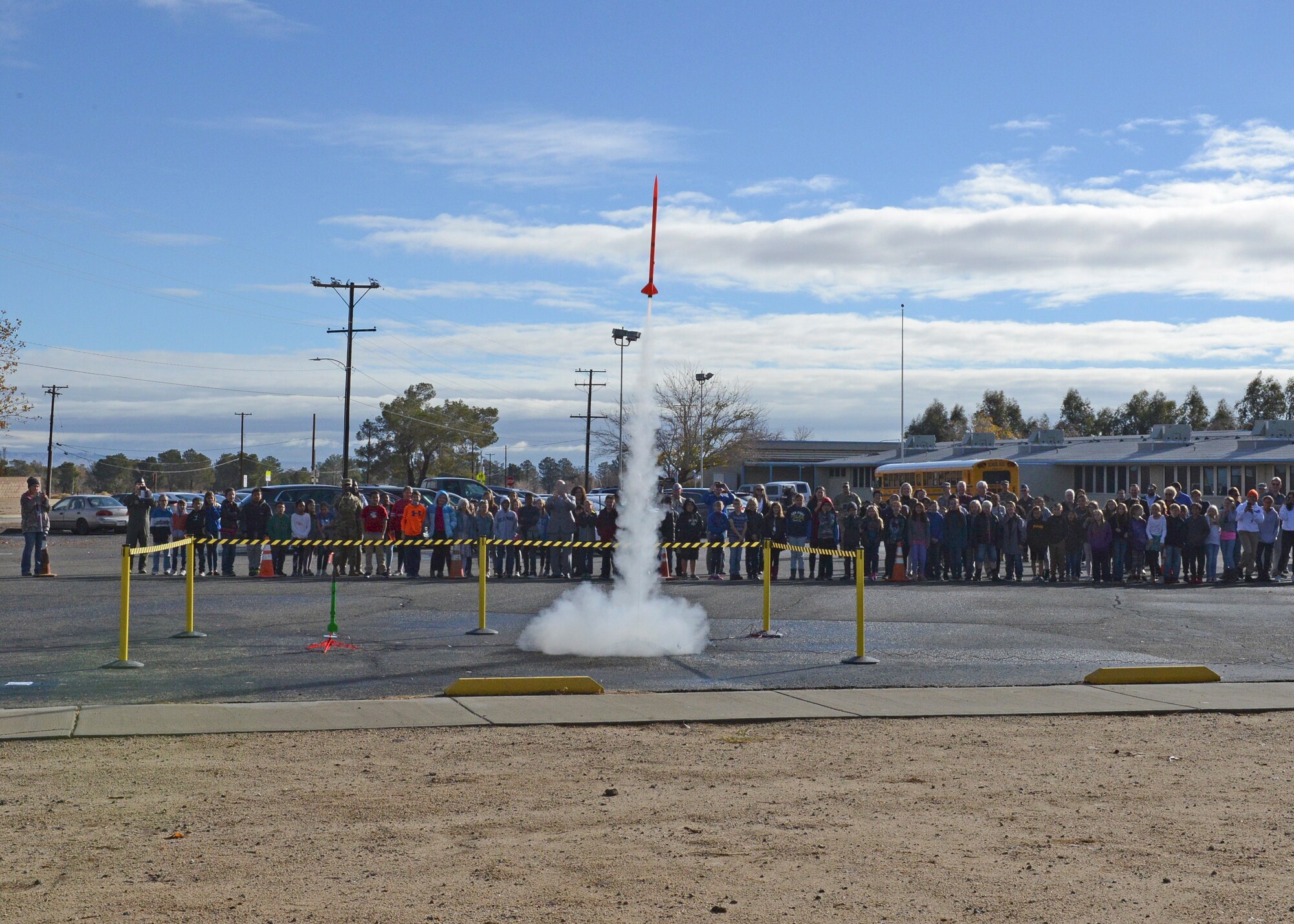 Students and guests at Branch Elementary on Edwards Air Force Base, California, watch a rocket take off as part of the grand opening of the base’s new STARBASE school program Dec. 7. The program is aimed at giving students a hands-on learning experience in the science, technology, engineering and mathematics fields. (U.S. Air Force photo by Kenji Thuloweit)