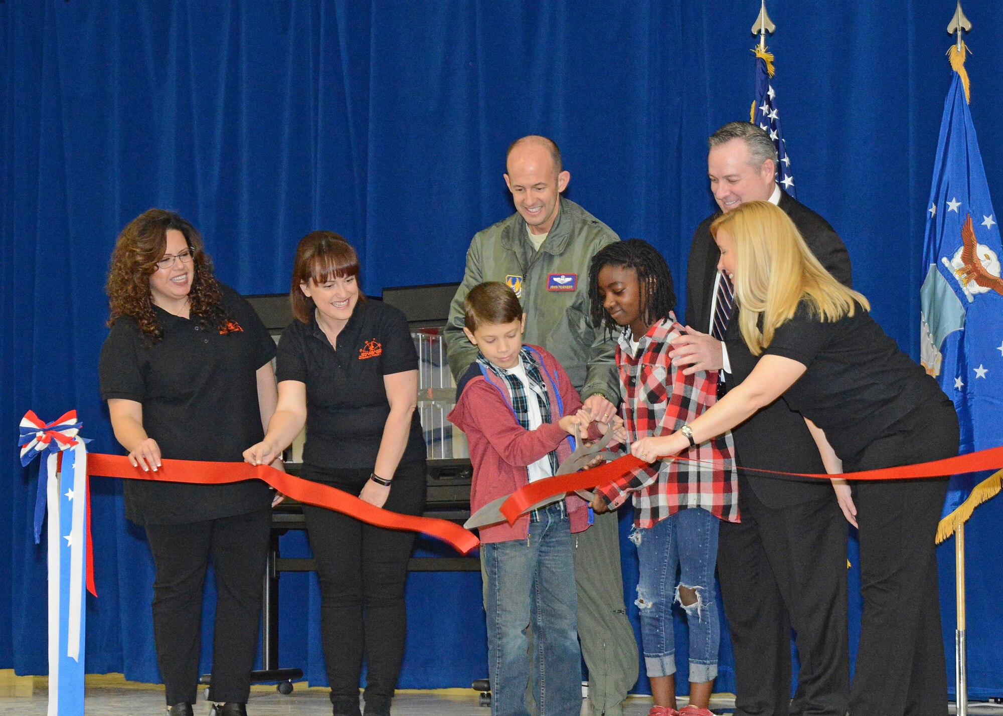 Members of the new STARBASE staff wearing the black shirts (left to right): Lourdes Talamantez, Caitlin Craig and Janet Creech, join fifth grade students Ananda and William, along with Brig. Gen. E. John Teichert, 412th Test Wing commander (center back), and Mike O’Toole, Department of Defense STARBASE program, in the ceremonial ribbon cutting to officially open STARBASE at Branch Elementary on Edwards Air Force Base. (U.S. Air Force photo by Kenji Thuloweit)