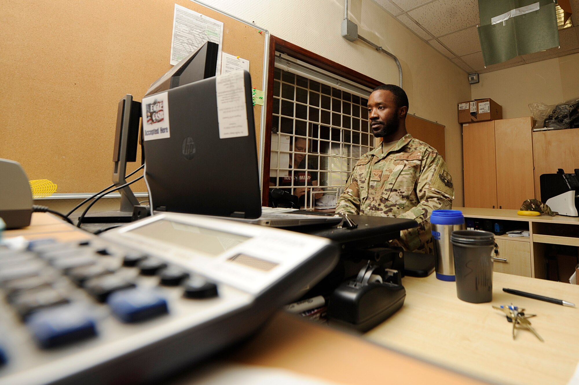 Senior Airman Yasin Sebaggala, 379th Expeditionary Comptroller Squadron (ECPTS) customer service cashier, helps a customer Dec. 8, 2018, at Al Udeid Air Base, Qatar. Airmen assigned to the 379th ECPTS financially support all U.S. military branches and 19 coalition partners across seven deployed locations. Up to $159 million flows through the 379 ECPTS, which contributes to everything from service member entitlements to purchasing mission-essential equipment. (U.S. Air Force photo by Tech. Sgt. Christopher Hubenthal)