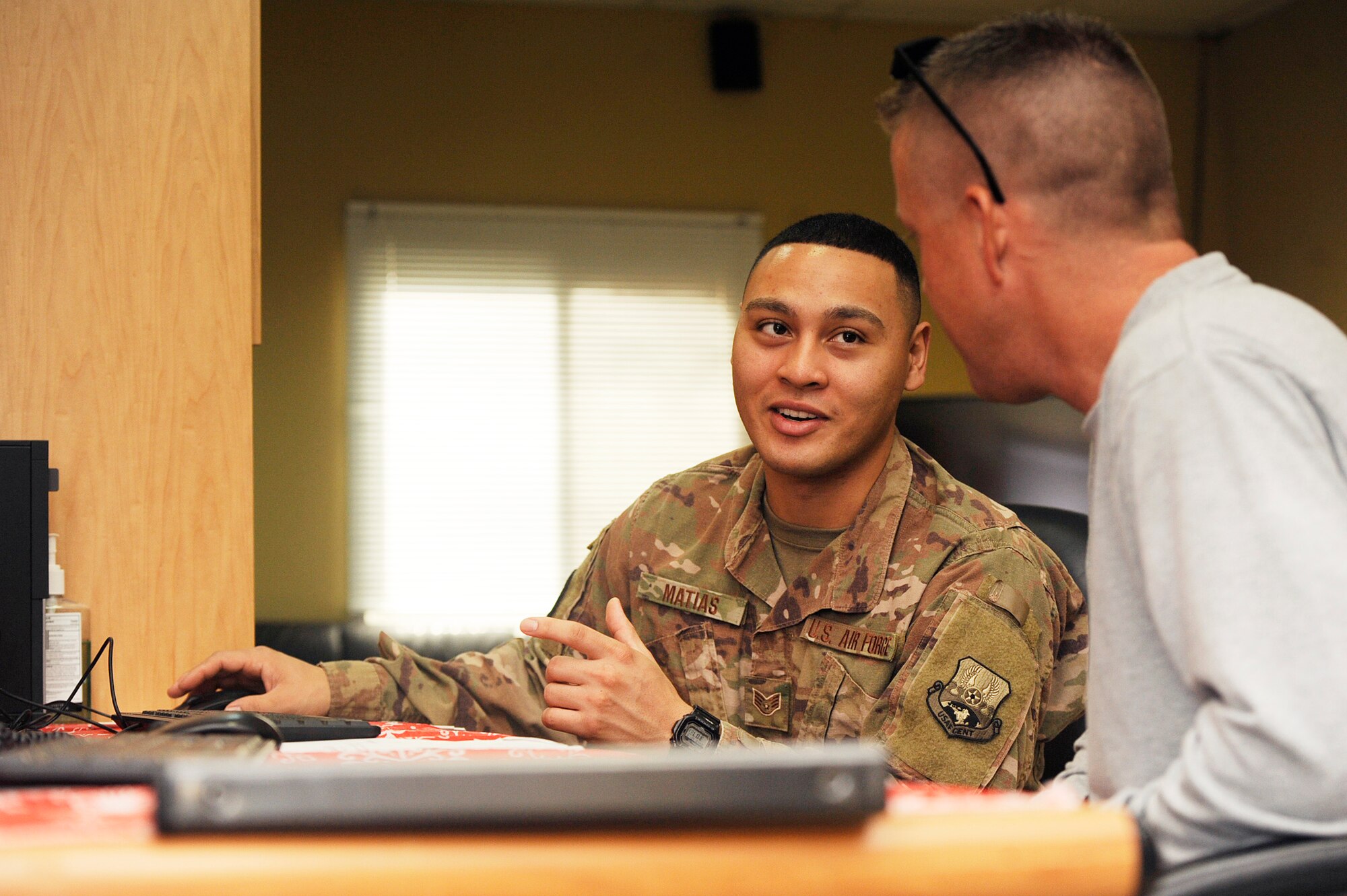 Staff Sgt. Jayson Matias, 379th Expeditionary Comptroller Squadron (ECPTS) customer service cashier, helps a customer fill out an accrual voucher Dec. 8, 2018, at Al Udeid Air Base, Qatar. Airmen assigned to the 379th ECPTS financially support all U.S. military branches and 19 coalition partners across seven deployed locations. With a budget ranging up to 159 million dollars, comptrollers here impact mission effectiveness in ways including ensuring service members receive their entitlements to purchasing necessary equipment in support of a mission. (U.S. Air Force photo by Tech. Sgt. Christopher 
Hubenthal)