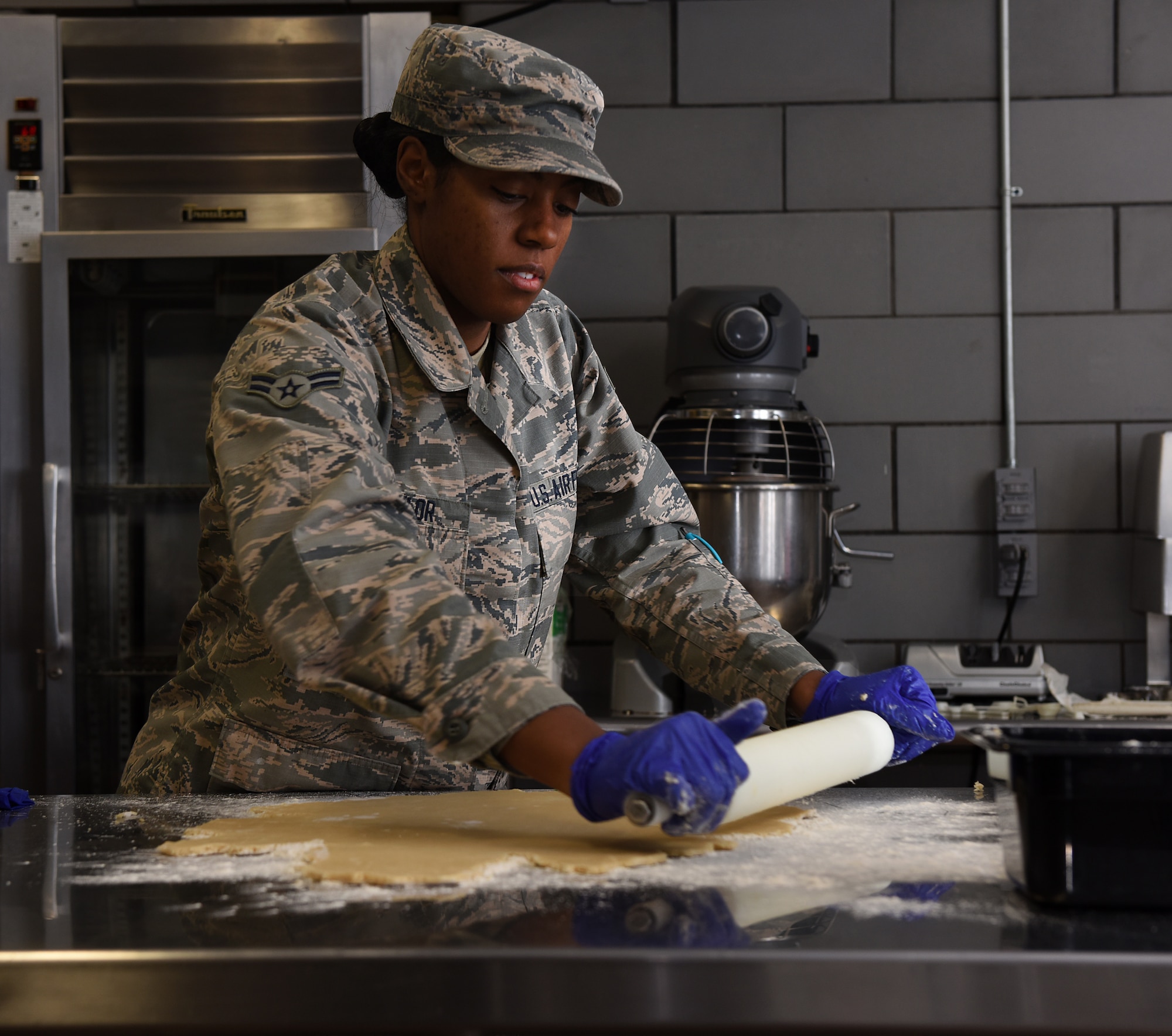 Airman 1st Class Alexis M. Taylor rolls dough for chocolate pudding pies.