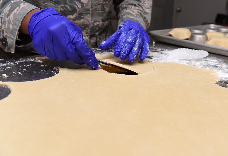 Airman 1st Class Alexis M. Taylor slices dough.