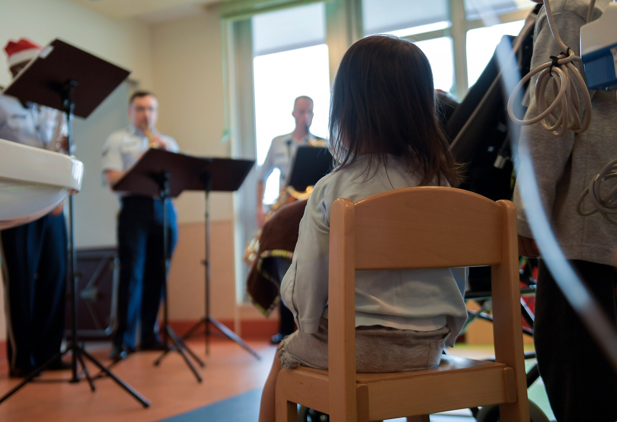 A child listens to holiday music performed by the U.S. Air Force Band of the Pacific