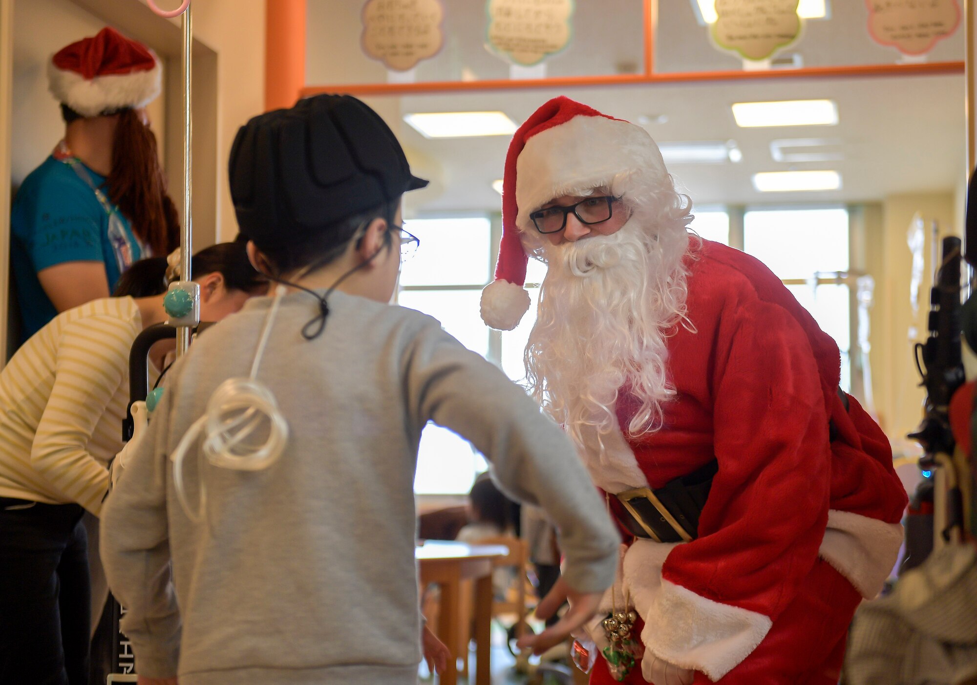 A member of Yokota Air Base, Japan, dressed as Santa Claus, dances with child