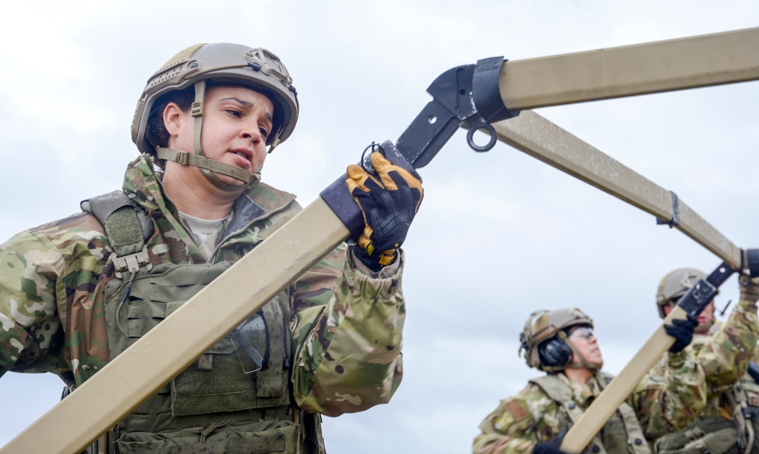 U.S. Air Force Staff Sgt. Tiara Pippens, 435th Contingency Response Squadron contingency response radio frequency transmission technician, connects parts of a Tent Model 60 during exercise Contested Forge on Grostenquin Air Base, France, Dec. 3, 2018. As part of Contested Forge, Pippens and other Airmen assigned to the 435th Contingency Response Group practiced their capability to set up, conduct, and defend austere airfield operations and a bare base. (U.S. Air Force photo by Staff Sgt. Timothy Moore)