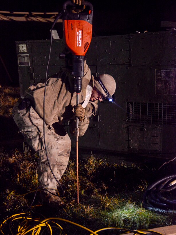 A U.S. Airman assigned to the 435th Contingency Response Group, 435th Air Ground Operations Wing, Ramstein Air Base, Germany, installs a grounding point for the electricity during exercise Contested Forge on Grostenquin Air Base, France, Dec. 3, 2018. As part of Contested Forge, Airmen assigned to the 435th CRG practiced their capability to set up, conduct, and defend austere airfield operations and a bare base. (U.S. Air Force photo by Staff Sgt. Timothy Moore)