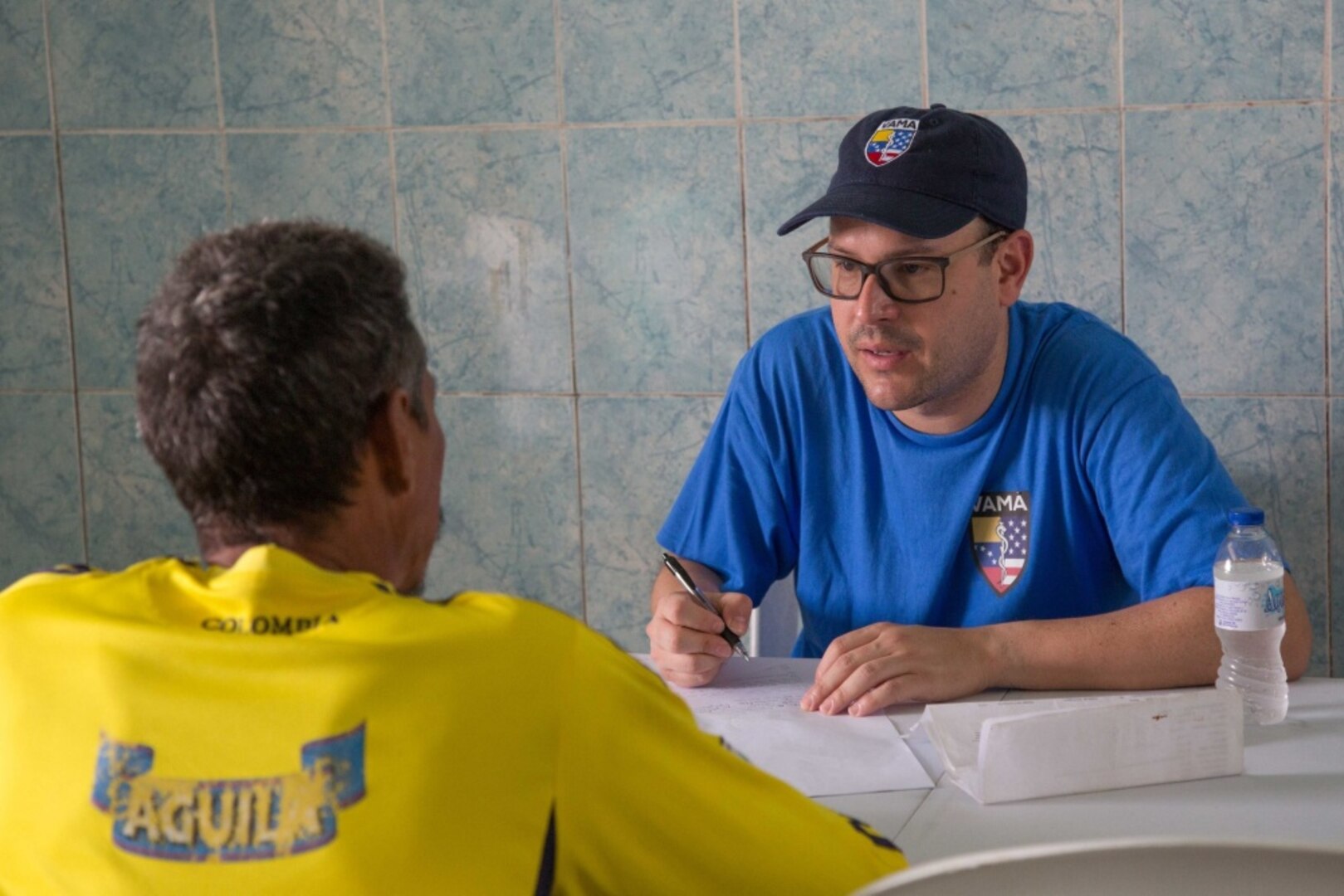 Jauier Andrade, a surgeon from New York City and a member of the Venezuelan American Medical Association, talks to a patient at one of two medical sites.
