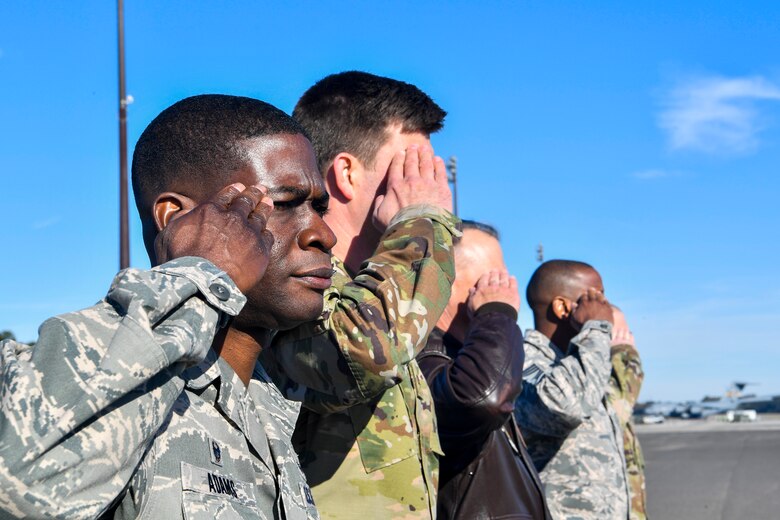 Air Force Col. Terrence Adams, Joint Base Charleston commander, and other base leaders salute Army Gen. Stephen Lyons, commander of U.S. Transportation Command, as his plane arrives Dec. 6, 2018, at Joint Base Charleston, S.C.