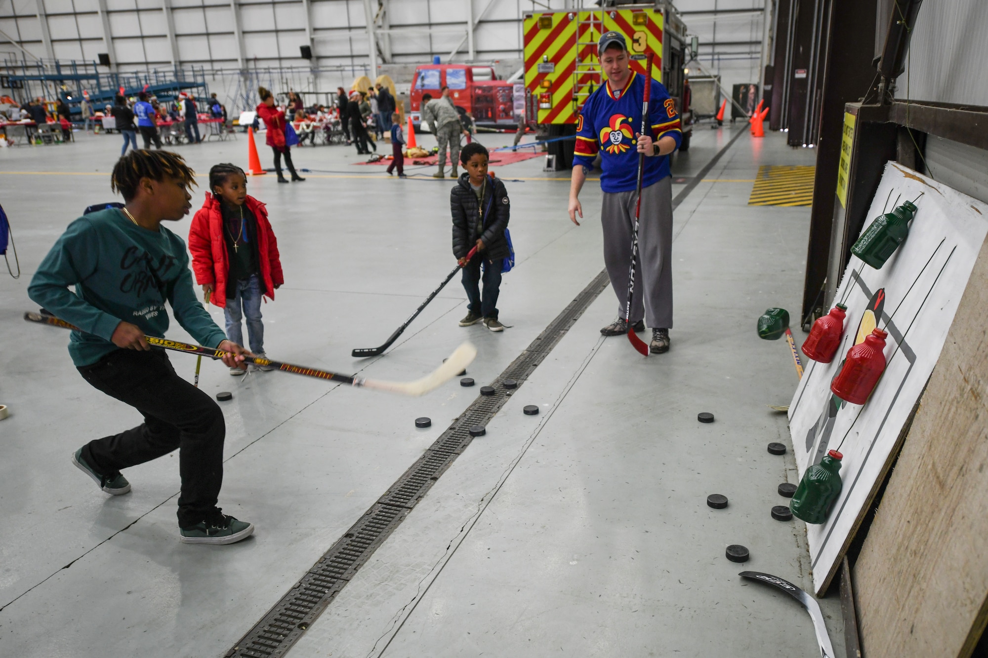Team Mildenhall children practice taking hockey shots during the annual Children’s Holiday Party at RAF Mildenhall, England, Dec. 8, 2018. The event provided Team Mildenhall families an opportunity to come together in celebration of the holiday season through games, food and crafts. (U.S. Air Force photo by Tech. Sgt. Emerson Nuñez)