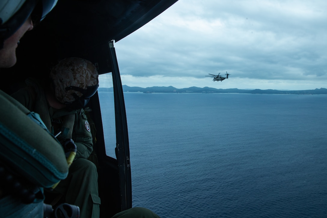 UH-1Y Huey helicopter crew members with Marine Medium Tiltrotor Squadron 262 (Reinforced) watch a CH-53E Super Stallion helicopter in flight during a simulated high altitude, low opening parachute jump and Reconnaissance and Surveillance mission as part of the 31st Marine Expeditionary Unit’s MEU Exercise, Okinawa, Japan, Dec. 8, 2018. Marines with the 31st MEU’s Amphibious Reconnaissance Platoon specialize in reconnaissance, surveillance and close-quarters tactics during amphibious operations. The 31st MEU, the Marine Corps’ only continuously forward-deployed MEU, provides a flexible and lethal force ready to perform a wide range of military operations as the premier crisis response force in the Indo-Pacific region.
