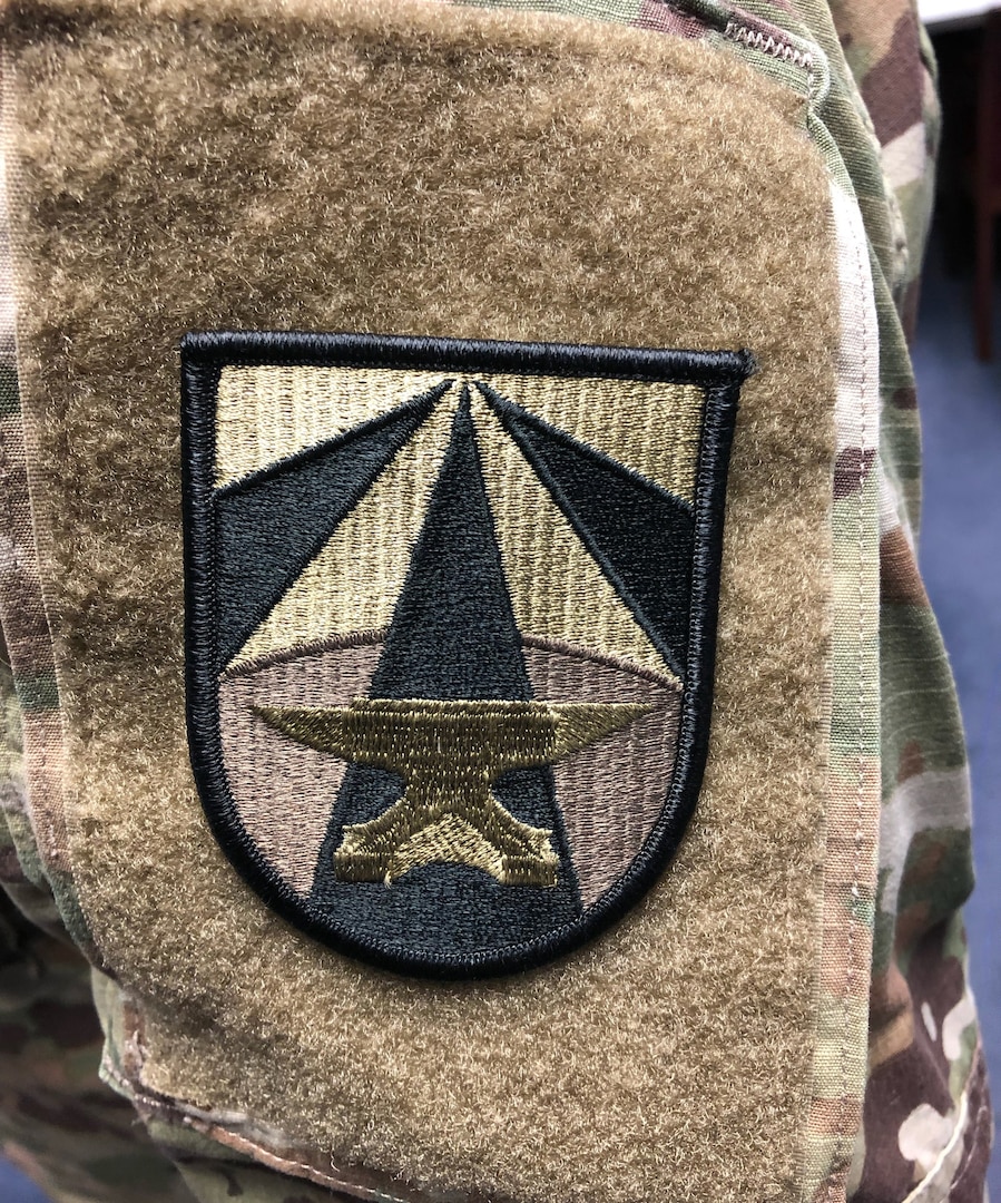 Shoulder sleeve insignia for Army Futures Command. With a golden anvil as its main symbol, the shoulder patch and distinctive unit insignia are a nod to former Gen. Dwight D. Eisenhower's personal coat of arms that used a blue-colored anvil.