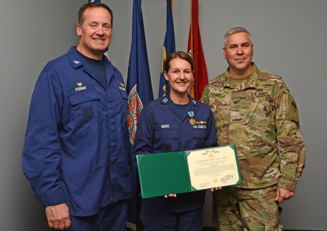 Lt. Brittany Akers, Waterways Mngt, Div. Chief for Coast Guard Sector North Carolina, stands with Wilmington District Commander Col. Robert Clark, right, and Captain Bion Stewart, Coast Guard Sector Commander North Carolina, after receiving the Army Achievment Medal. Lt. Akers completed the U.S. Coast Guard Waterways Management Industry Training while assigned to the Wilmington District's Navigation Branch from May 1 through Oct. 30.