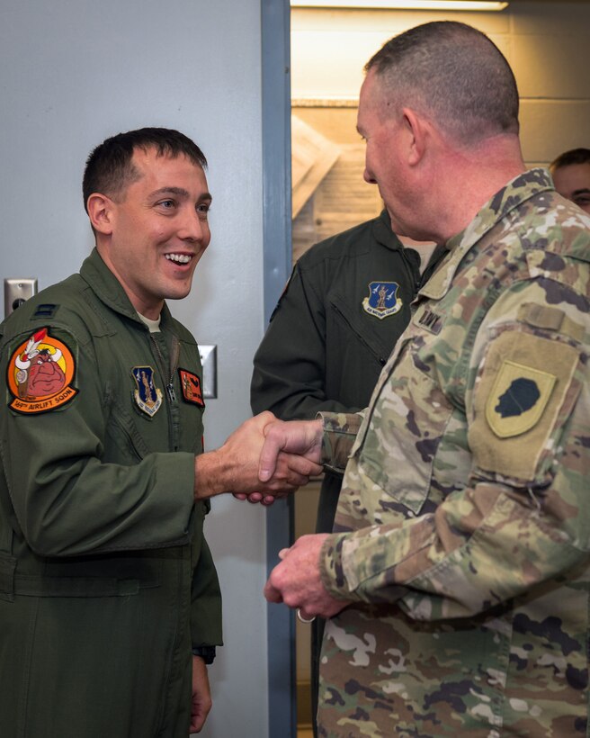 U.S. Army Maj. Gen. Richard Hayes, Jr., right, The Adjutant General for the Illinois National Guard, coins Air Force Capt. Daniel Whitlow, a C-130H3 Hercules pilot with the 169th Airlift Squadron, in recognition of his outstanding job performance in Peoria, Ill., Dec. 2, 2018.