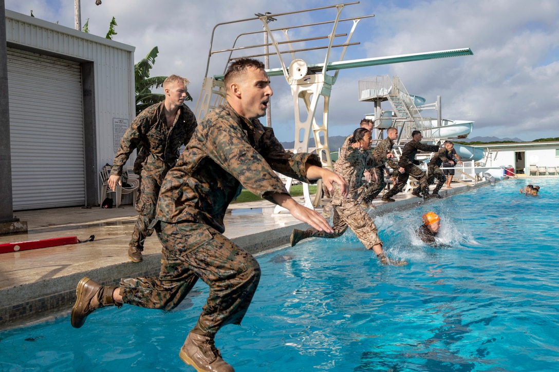 A group of Marines jump into a pool.