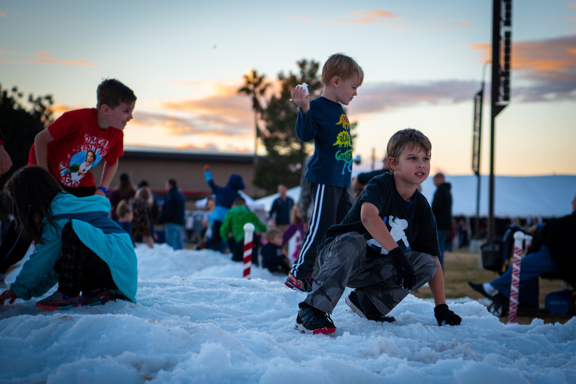 Children play on a pile of snow during Holiday Magic 2018, Dec. 7, 2018, at Luke Air Force Base, Ariz.