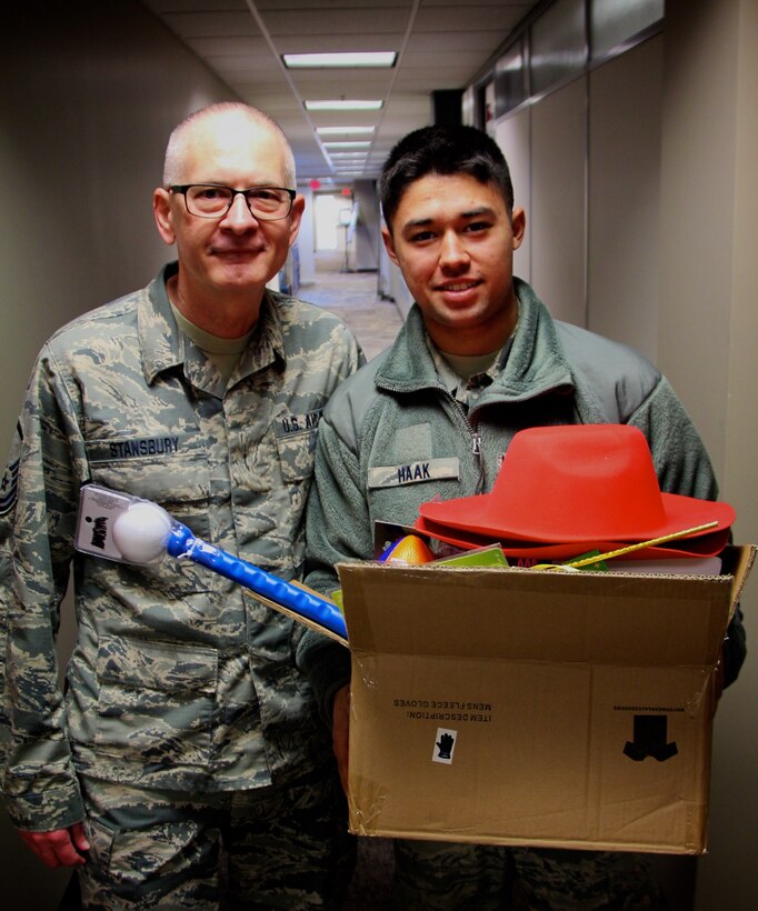 Noncommissioned Officer in Charge of Newcomers, Master Sgt. Tim Stansbury, 932nd Airlift Wing, helps a member with toys for children during the December Unit Training Assembly held December 1, 2018 at Scott Air Force Base, Illinois.  The Airman and Family Readiness office handed out a variety of toys and cookie donations during the weekend for 932nd AW reservists to use during the holiday season.  Stansbury also gives monthly introductory newcomers briefings to the newest additions at the 932nd AW during the Newcomers Orientation Course, a two day course which provides new members valuable information about the mission of the 932nd.  They hear from various offices to understand what it means to participate as a new member of Team Scott. (U.S. Air Force photo by Lt. Col. Stan Paregien)