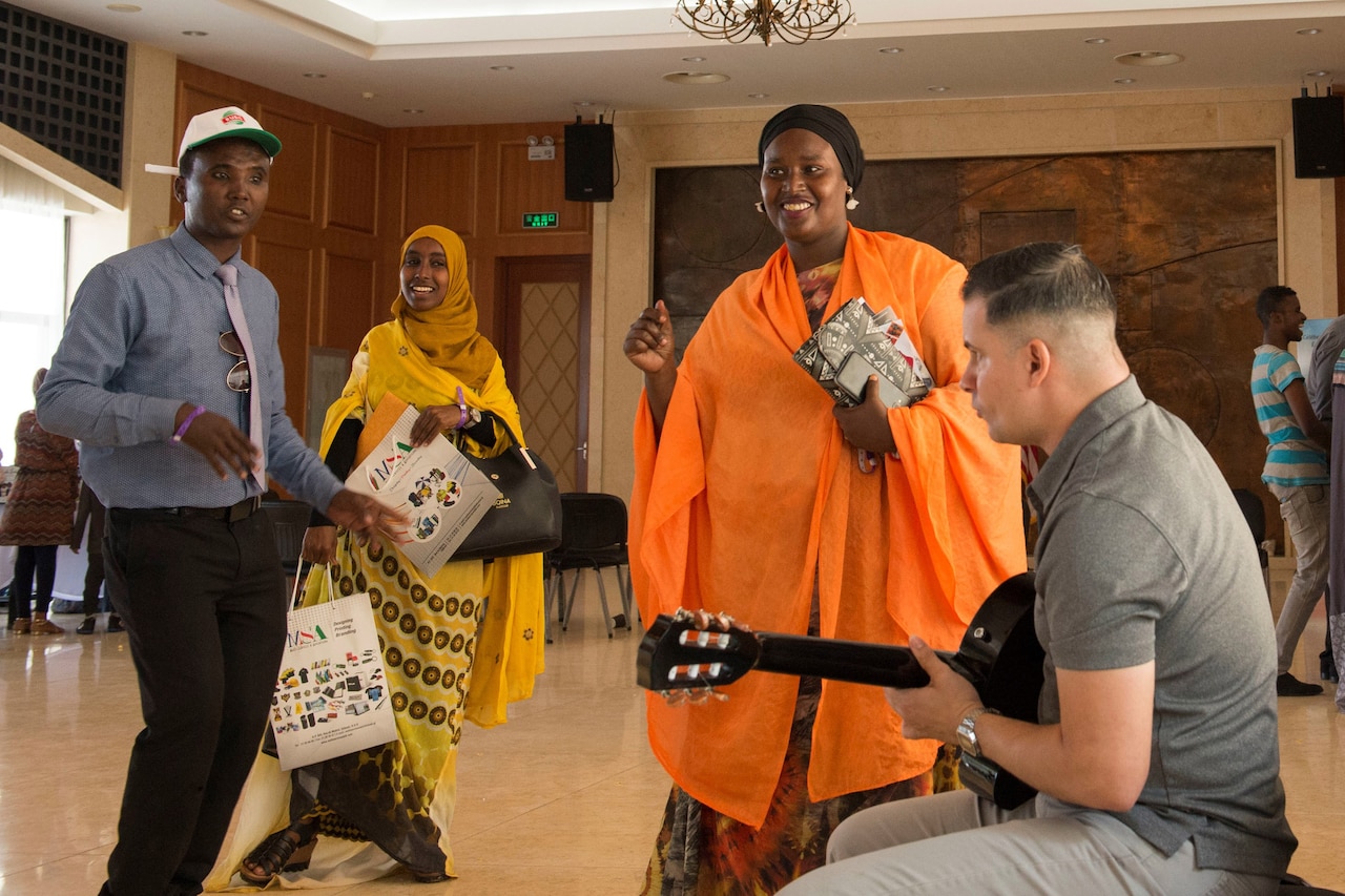 A U.S. service member plays guitar for citizens of Djibouti on the Horn of Africa during a cultural event.