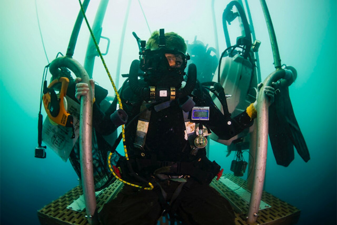 A diver holds onto a platform.