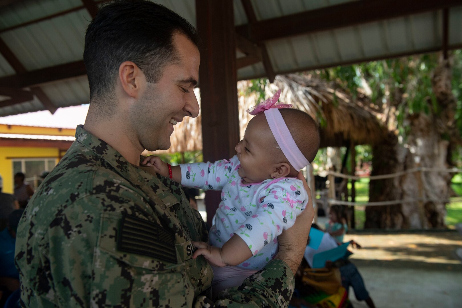 A Navy lieutenant from the USNS Comfort, a hospital shit, holds a baby in Honduras.