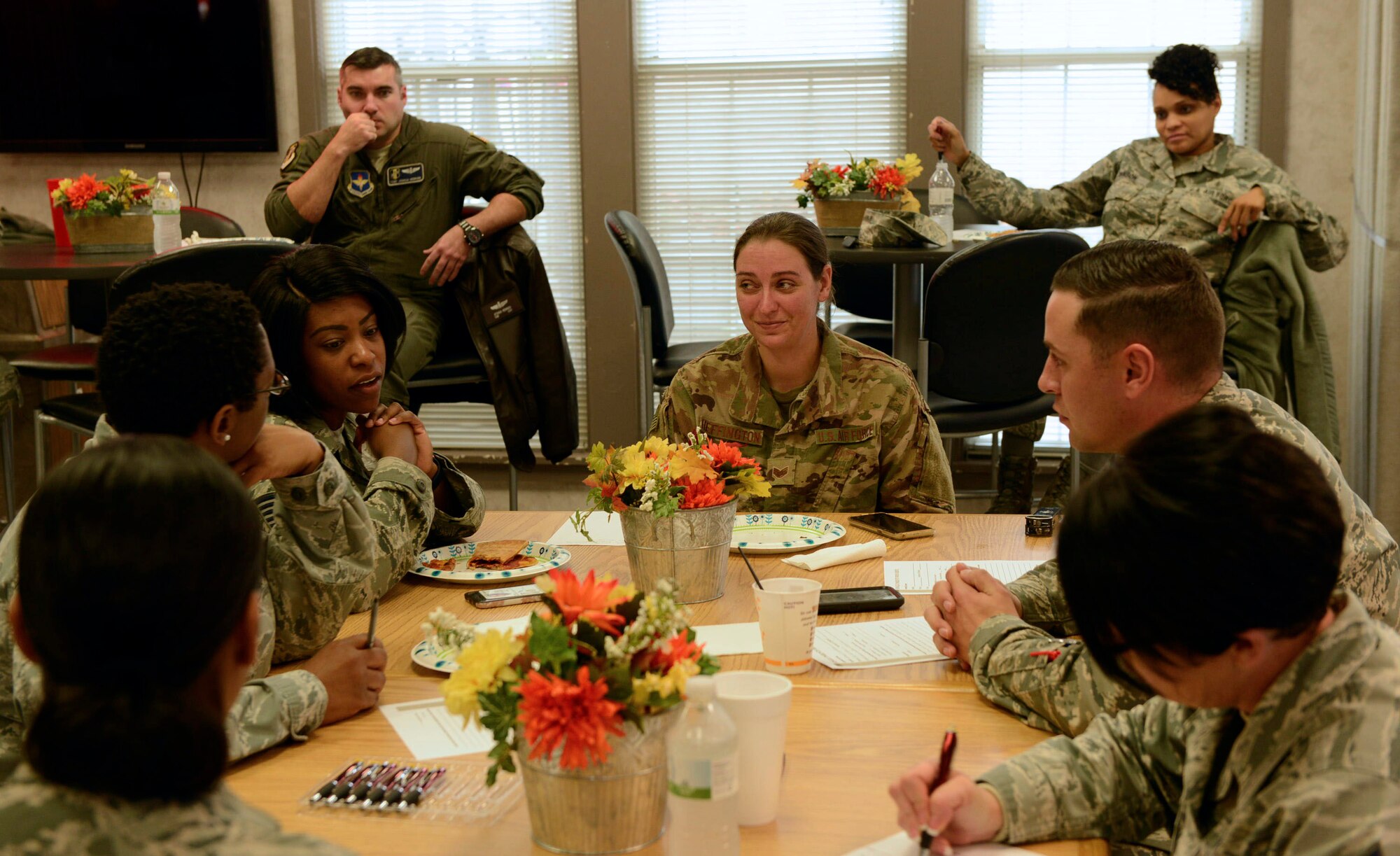 People in uniform sit around a table