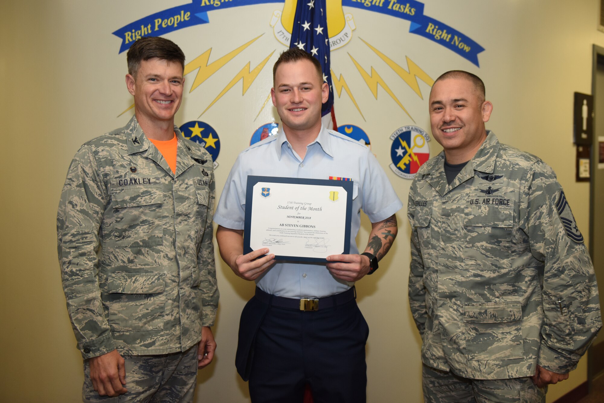 U.S. Air Force Col. Thomas Coakley, 17th Training Group commander, presents the 312th Training Squadron Student of the Month award to Airman Steven Gibbons, 312th TRS student, at Brandenburg Hall on Goodfellow Air Force Base, Texas, Dec. 7, 2018. The 312th TRS’s mission is to provide Department of Defense and international customers with mission ready fire protection and special instruments graduates and provide mission support for the Air Force Technical Applications Center. (U.S. Air Force photo by Senior Airman Scott Jackson/Released)