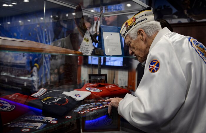 Ed Hall, Pearl Harbor Survivor, observes challenge coins on display in the Thunderbird Museum Dec. 7, 2018 at Nellis Air Force Base, Nevada. Hall recalled having a challenge coin many years ago similar to the ones on display. (U.S. Air Force photo by Airman 1st Class Bailee A. Darbasie)