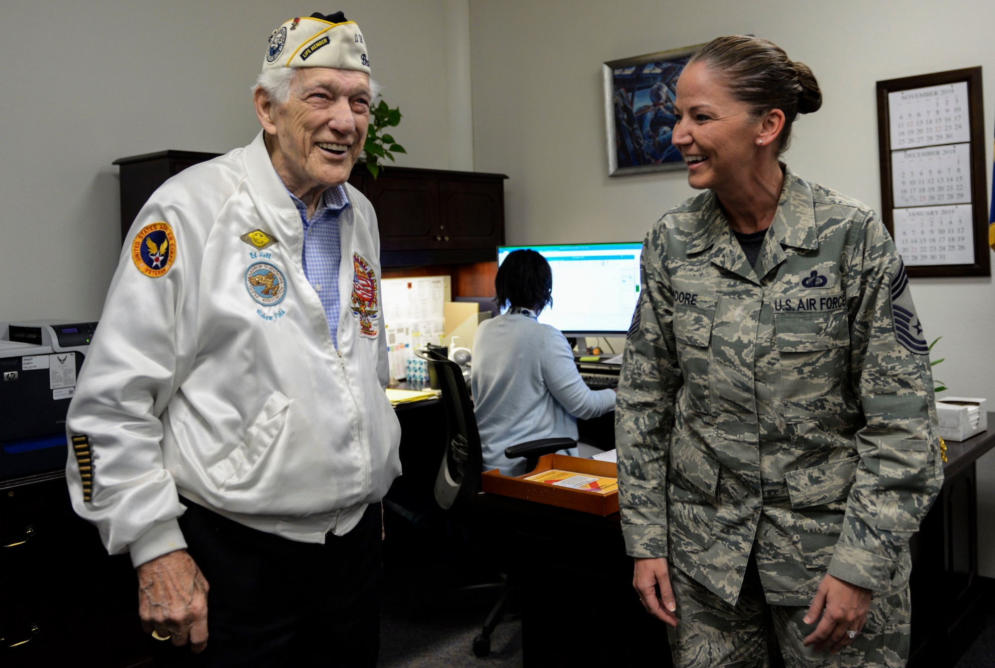 Ed Hall, Pearl Harbor Survivor, laughs with Chief Master Sgt. Tammy Moore, 99th Comptroller Squadron Superintendent, Dec. 7, 2018 on Nellis Air Force Base, Nevada. Hall stopped by the 99th Air Base Wing headquarters to meet with 99th ABW leadership. (U.S. Air Force photo by Airman 1st Class Bailee A. Darbasie)