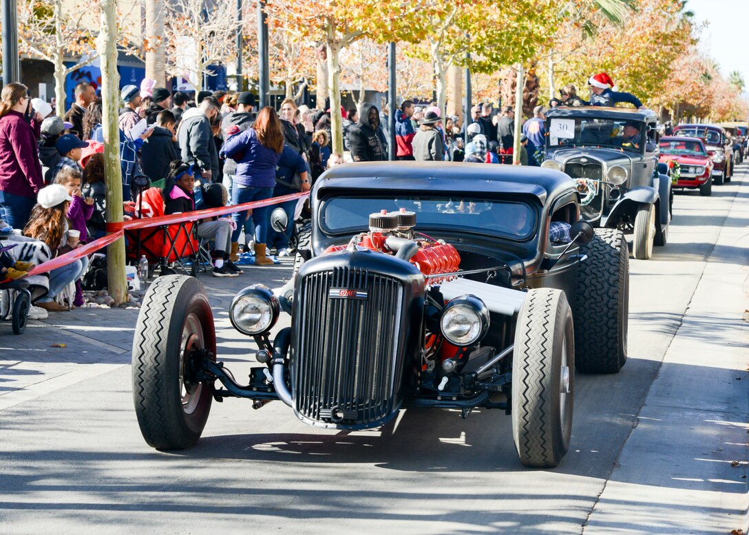 A procession of custom-built hotrods, classic and muscle cars drive down Lancaster Boulevard during the the Sleigh Rides through the City parade in Lancaster, California, Dec. 1. (U.S. Air Force photo by Giancarlo Casem)