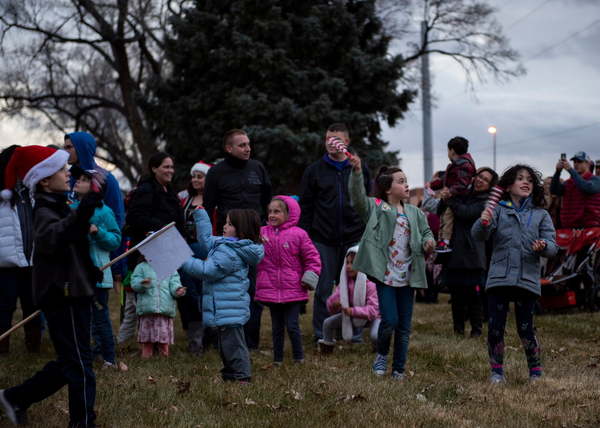 Families wait for the Christmas tree to be lit at Kirtland Air Force Base, N.M., Dec 6, 2018. In order for the Christmas tree to be lit, those with jingle bells were required to ring the bells as loud as they could. (U.S. Air Force photo by Airman 1st Class Austin J. Prisbrey)