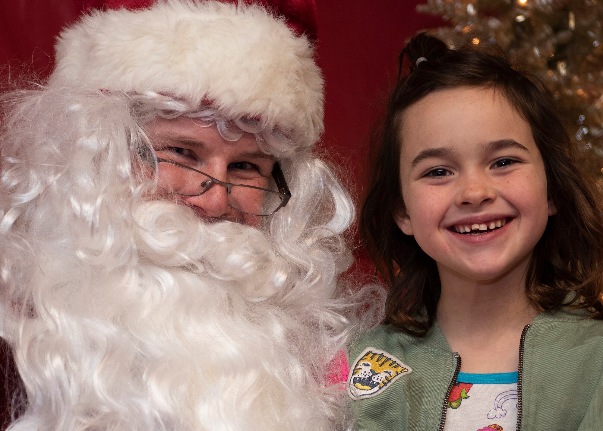 Emma Therrien poses for a picture with Santa Claus at Kirtland Air Force Base, N.M., Dec. 6, 2018. Children attending the Christmas tree lighting were able to get a pictures with Santa Claus and tell him what they wanted for Christmas. (U.S. Air Force photo by Airman 1st Class Austin J. Prisbrey)
