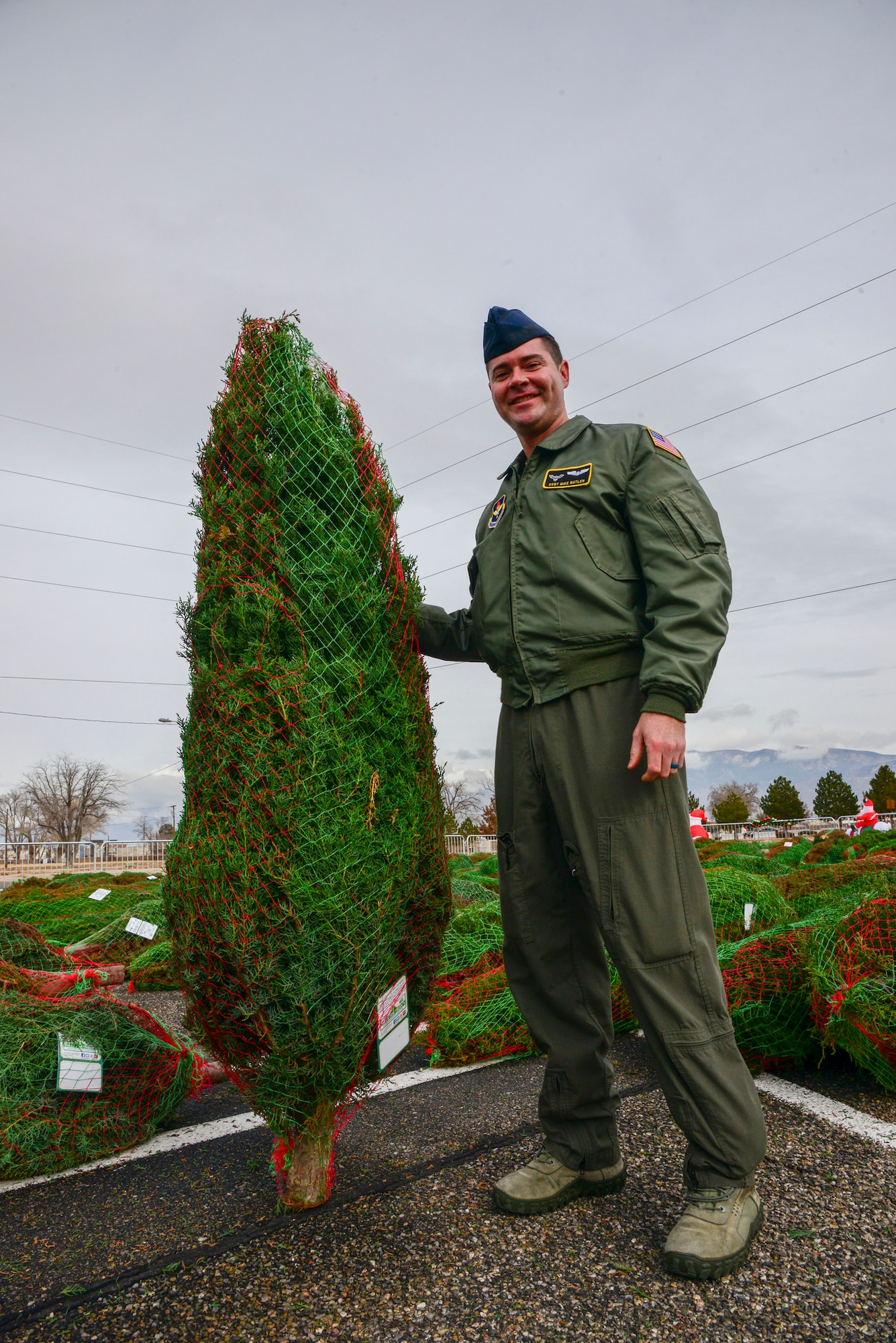 Staff Sgt. Mike Butler, 415th Special Operations Squadron, poses with a Christmas tree he picked out during the Trees for Troops event Dec. 7 at the base chapel here.  The two-day event provided free trees for members of Team Kirtland. Last year the program delivered 17,400 Christmas trees to 70 U.S. military bases; 250 trees delivered to four international bases; and is in its 14th year. (U.S. Air Force photo by Jessie Perkins)