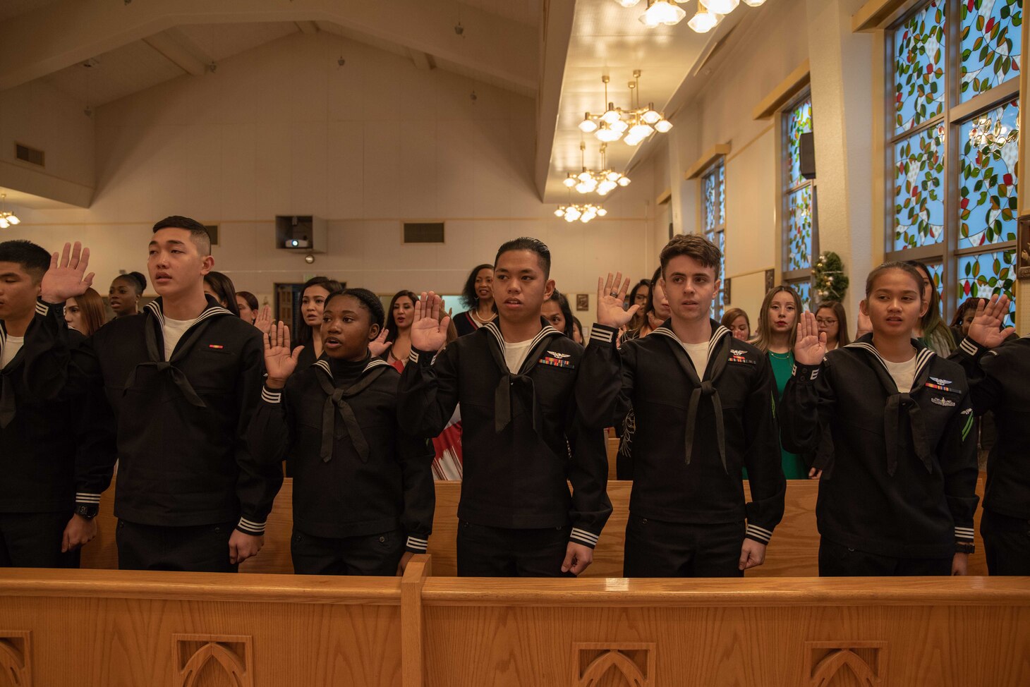 YOKOSUKA (Dec. 6, 2018) Sailors and dependents take the Oath of Allegiance, pledging to become U.S. citizens in the Chapel of Hope, Command Fleet Activites Yokosuka. Ronald Reagan, the flagship of Carrier Strike Group 5, provides a combat-ready force that protects and defends the collective maritime interests of its allies and partners in the Indo-Pacific region.