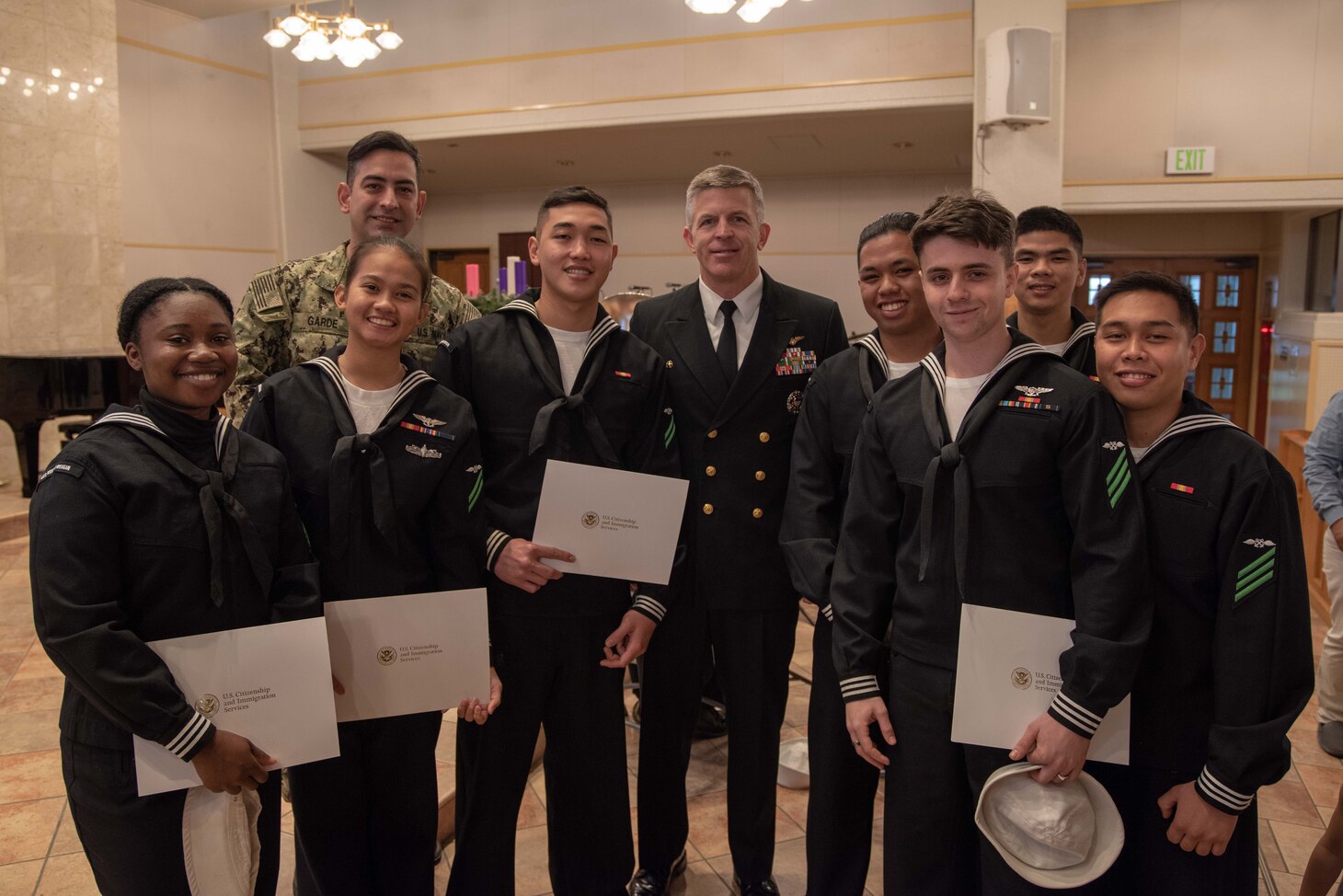 YOKOSUKA (Dec. 6, 2018) Capt. Patrick Hannafinn, USS Ronald Reagan's Commanding Officer, takes a group photo with Sailors granted their U.S. American citizenship in the Chapel of Hope, Command Fleet Activites Yokosuka. Ronald Reagan, the flagship of Carrier Strike Group 5, provides a combat-ready force that protects and defends the collective maritime interests of its allies and partners in the Indo-Pacific region.