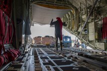 Senior Airman Walter Frank, 36th Airlift Squadron loadmaster, directs an equipment operator from the 374th Logistics Readiness Squadron into position during Operation Christmas Drop 2018 at Andersen Air Force Base, Guam, Dec. 9, 2018. Prior to being loaded onto the planes, the 374th LRS Combat Mobility Flight packs the parachutes and builds the Coastal Humanitarian Air Drop bundles that will be used throughout OCD.