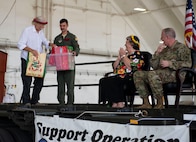Bruce Best, researcher, University of Guam, far left, prepares to hand cultural gifts to the official party during the Operation Christmas Drop Push Ceremony at Andersen Air Force Base Dec. 10.  During the ceremony, the first of nearly 100 boxes of humanitarian goods was pushed into a C-130 before being delivered to 56 islands across the Commonwealth of the Northern Mariana Islands, the Federated States of Micronesia and the Republic of Palau.