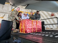 From left, Maj. Gen. John Gordy, commander, U.S. Air Force Expeditionary Center; Heather Coble, deputy chief of mission, Kolonia, Pohnpei and Federated States of Micronesia; Bruce Best, researcher, University of Guam; Brig. Gen. Gentry Boswell, commander, 36th Wing; and Col. Otis Jones, commander, 374th Airlift Wing push a box of humanitarian goods into a C-130 during the Operation Christmas Drop Push Ceremony at Andersen Air Force Base Dec. 10.  During the ceremony, the first of nearly 100 boxes of humanitarian goods was pushed into the C-130 before being delivered to 56 islands across the Commonwealth of the Northern Mariana Islands, the FSM and the Republic of Palau.