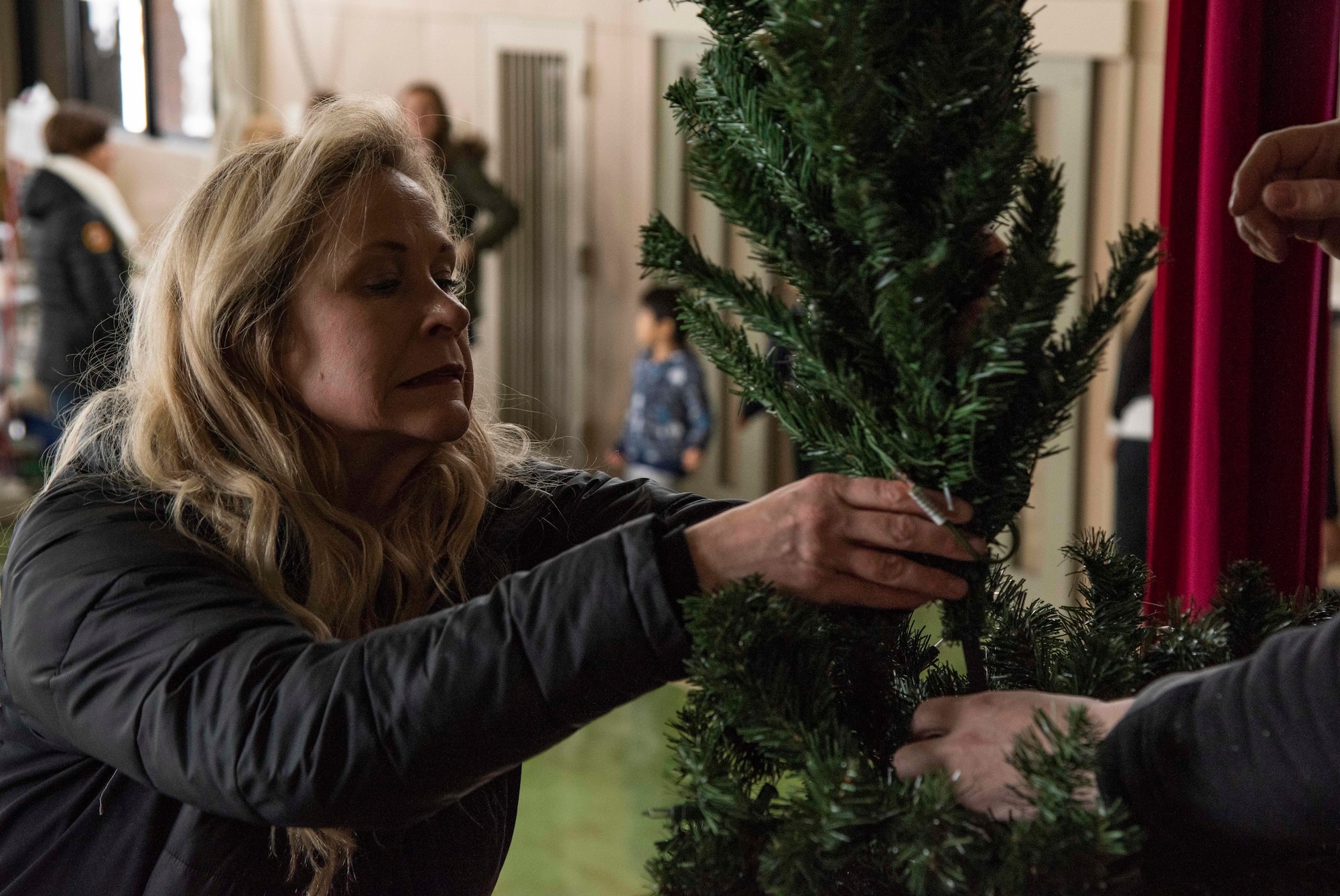 Kristen Cockrum, wife of U.S. Air Force Col. Jason Cockrum, the 35th Operations Group commander, sets up a Christmas tree during a Hirosaki Ai-Sei-En orphanage visit, at Hirosaki, Japan, Dec. 8, 2018. During the visit, members dressed as Santa Claus, Mrs. Claus, elves and reindeer who delivered gifts from the children’s wish lists. (U.S. Air Force photo by Senior Airman Sadie Colbert)