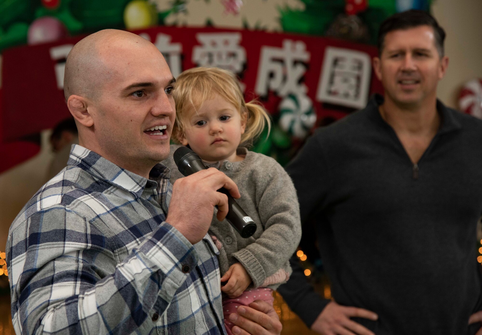 U.S. Air Force 1st Lt. Taylor Hollister, the 35th Operations Group chief of intelligence, introduces himself to familiar faces, while holding his daughter, Ella, during a Hirosaki Ai-Sei-En orphanage visit, in Hirosaki, Japan, Dec. 8, 2018. Hollister speaks Japanese fluently and provided assistance in organizing the event through his skills and past experience in visiting the center. (U.S. Air Force photo by Senior Airman Sadie Colbert)