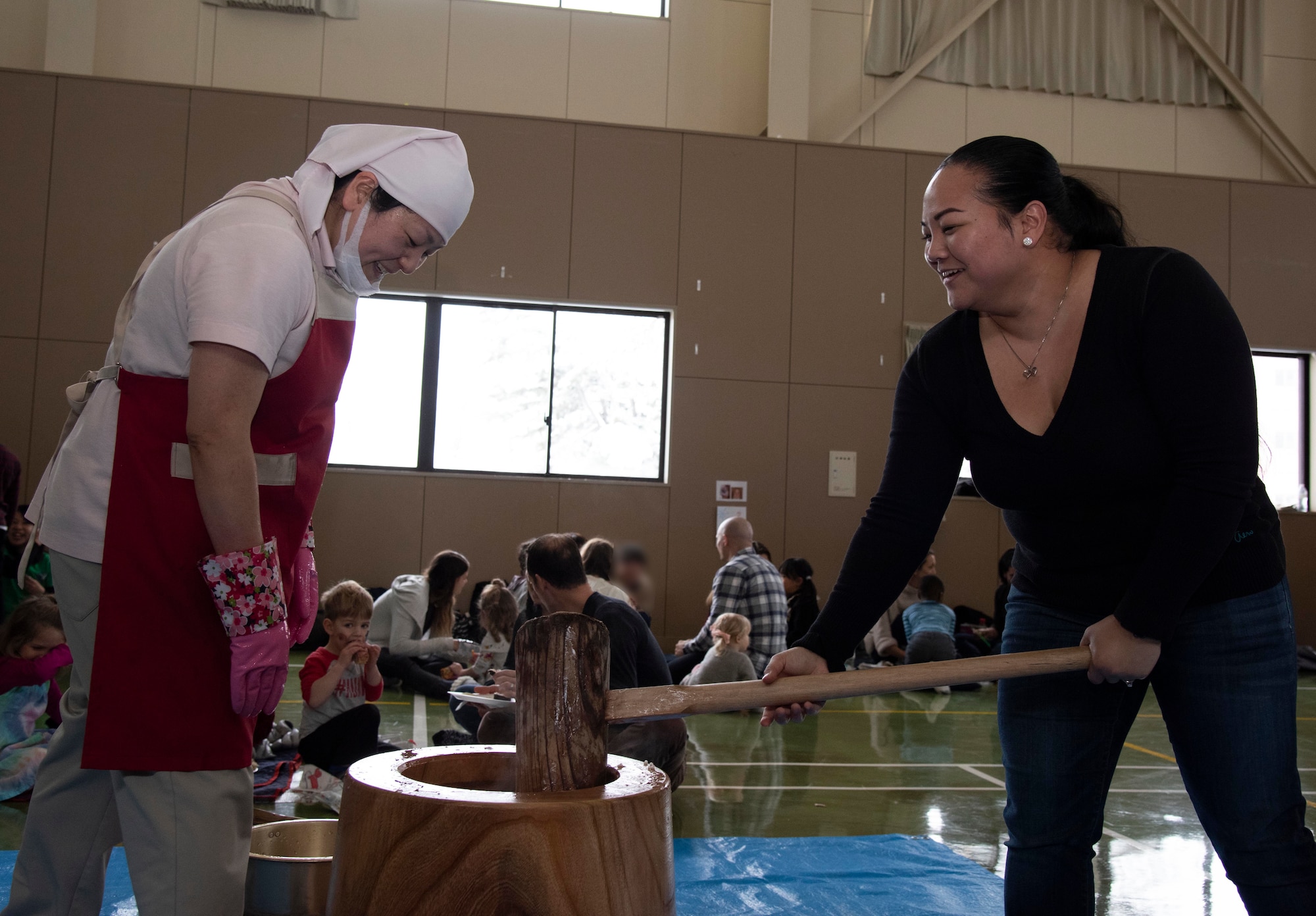 A Hirosaki Ai-Sei-En chef, left, and U.S. Air Force Tech. Sgt. Cherylin Santos, a 35th Operations Group command support staff section chief, pounds mochi during a Hirosaki Ai-Sei-En orphanage visit at Hirosaki, Japan, Dec. 8, 2018. The 35th Operations Group coordinates annually with the orphanage to provide food, games, presents and holiday cheer to the children. (U.S. Air Force photo by Branden Yamada)