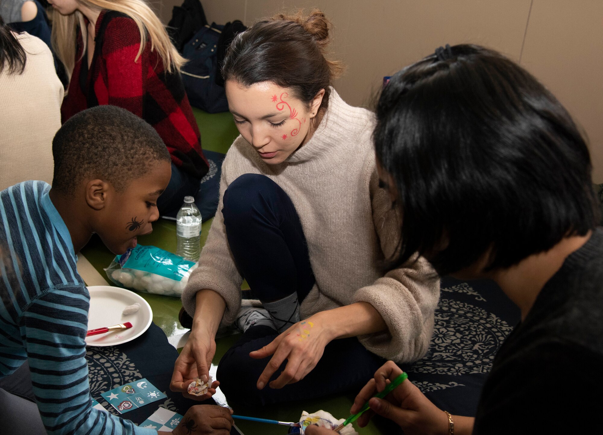 Rocco Pompa, left, son of U.S. Air Force Lt. Col. Doyle Pompa, the 35th Operations Group deputy commander, paints with Capt. Jaclyn Dzieciolowski, center, the 35th OG command support staff officer in charge, during a Hirosaki Ai-Sei-En orphanage visit at Hirosaki, Japan, Dec. 8, 2018. The orphanage encouraged volunteers to bring as many of their children as possible to give the children at the orphanage an opportunity to play with their own small-sized American friends. (U.S. Air Force photo by Branden Yamada)