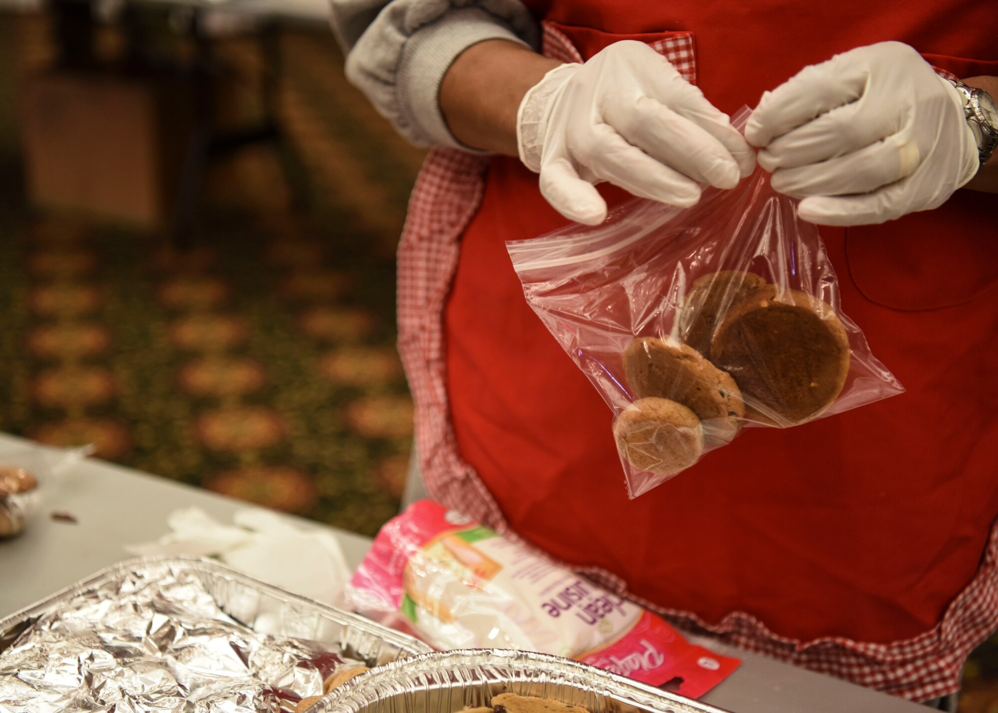 A volunteer bags an assortment of cookies during Operation Sweet Treat at Osan Air Base, Republic of Korea, Dec. 10, 2018. An assortment of four cookies was placed in each bag for the service members to receive for the holidays. The cookies were combined with candy and Moon Pies before being sent out for delivery. (U.S. Air Force photo by Airman 1st Class Ilyana A. Escalona)