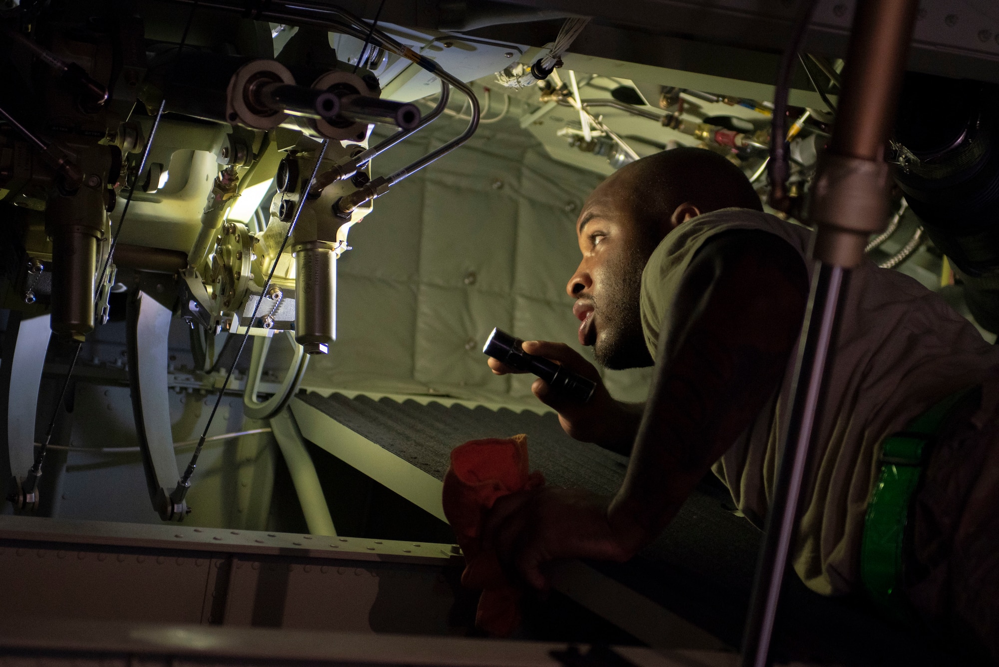 Staff Sgt. Christopher Canto, 374th Aircraft Maintenance Squadron flying crew chief, conducts his pre-flight inspection during Operation Christmas Drop 2018 at Andersen Air Force Base, Guam, Dec. 9, 2018.