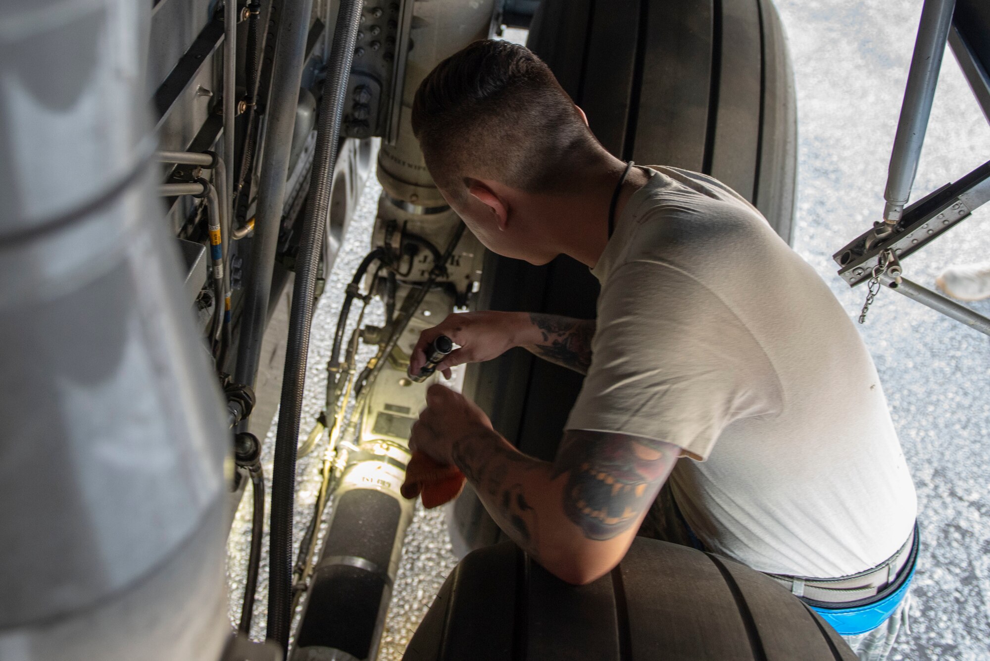 Staff Sgt. Matthew Haston, 374th Aircraft Maintenance Squadron electrical and environmental systems craftsman, looks over the tires of a C-130J Super Hercules during a pre-flight inspection during Operation Christmas Drop 2018 at Andersen Air Force Base, Guam, Dec. 9, 2018.