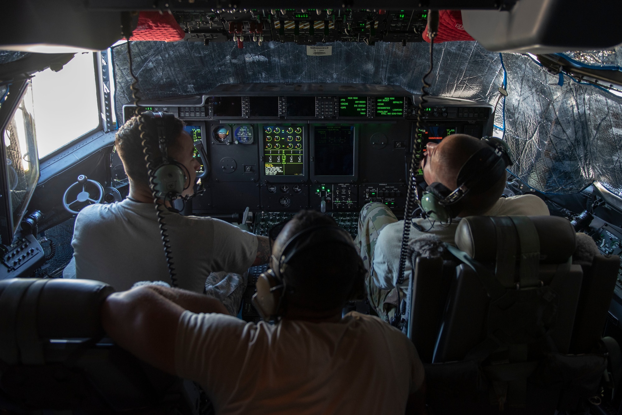 Airmen from the 374th Aircraft Maintenance Squadron monitor the instrument readings while communicating with the flying crew chief via radio during an aircraft refueling process at Operation Christmas Drop 2018 at Andersen Air Force Base, Guam, Dec. 9, 2018.