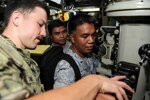 PUERTO PRINCESA, Philippines (Dec. 10, 2018) – Lt. j.g. Aaron Sims, assigned to the Los Angeles-class attack submarine USS Greeneville (SSN 772), shows members of the Philippine Navy how to operate a periscope during a tour of the submarine, Dec. 10. Land is in the Philippines on a scheduled port visit to provide maintenance, hotel services, and logistical support to submarines and surface ships in the 5th and 7th Fleet areas of responsibility. Land's visit promotes ongoing theater security cooperation efforts furthering the longstanding partnership between the United States and Philippine navies.