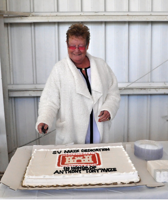 Gayle Mayes, widow of Anthony “Tony” Maze cuts cake following the Dedication Ceremony for Survey Vessell Maze, Dec. 7.