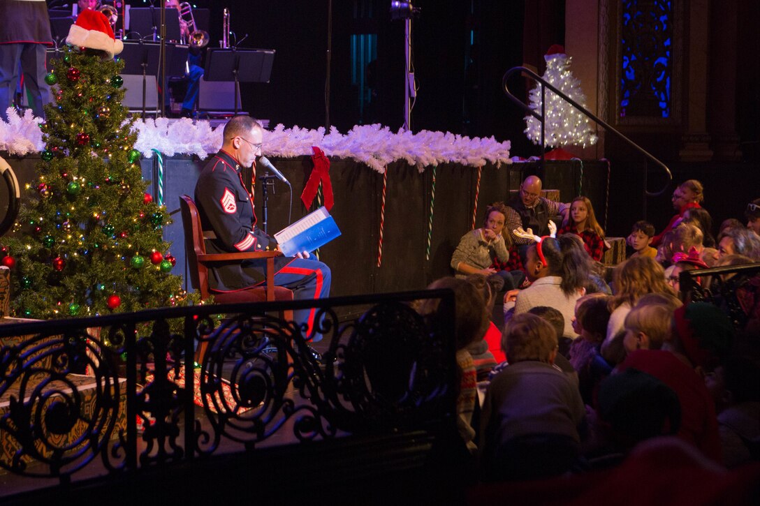 Staff Sgt. Marcus B. Bailey, enlisted conductor of the Marine Forces Reserve Band, reads “Twas the Night Before Christmas” to children attending the annual holiday concert at Saenger Theatre in New Orleans, Dec. 9, 2018. The performance is one of several holiday concerts the band arranged throughout December to promote the Marine Corps Reserve Toys for Tots program, which donates toys to less fortunate children in the community. (U.S. Marine Corps photo by Lance Cpl. Samantha Schwoch)