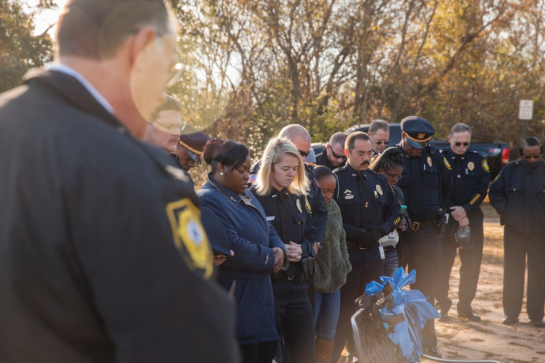 Police officers from Americus, Ga., bow their heads during a prayer for Lance Cpl. Nicholas Smarr, during a wreath laying ceremony at Smarr’s grave site in Americus, Dec. 7, 2018. Smarr and fellow officer Jody Smith were killed in action when responding to a call in Americus on Dec. 7, 2016. Smarr was also a Reserve Marine. (U.S. Marine Corps photo by Cpl. Niles Lee)