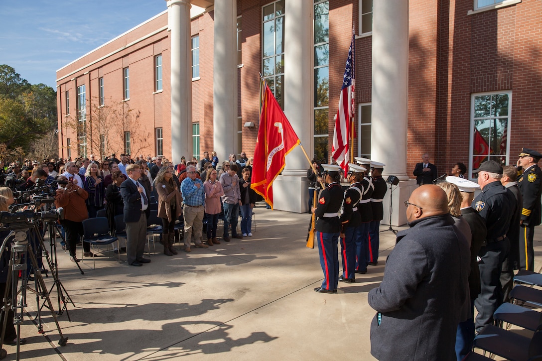 Guests attending Lance Cpl. Nicholas Smarr’s Navy and Marine Corps Medal presentation stand during the playing of the Star Spangled Banner at Georgia Southwestern State University in Americus, Ga., Dec. 7, 2018. Smarr, a Reserve Marine, was posthumously awarded the Navy and Marine Corps Medal for his actions that cost him his life two years ago while serving as a police officer for the Americus Police Department. (U.S. Marine Corps photo by Cpl. Niles Lee)
