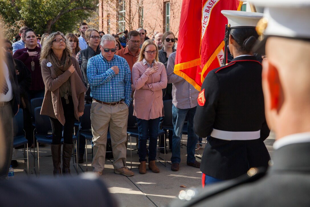The family of Lance Cpl. Nicholas Smarr stand during the playing of the Star Spangled Banner at his Navy and Marine Corps Medal presentation ceremony at Georgia Southwestern State University in Americus, Ga., Dec. 7, 2018. Smarr, a Reserve Marine, was posthumously awarded the Navy and Marine Corps Medal for his actions that cost him his life two years ago while serving as a police officer for the Americus Police Department. (U.S. Marine Corps photo by Cpl. Niles Lee)
